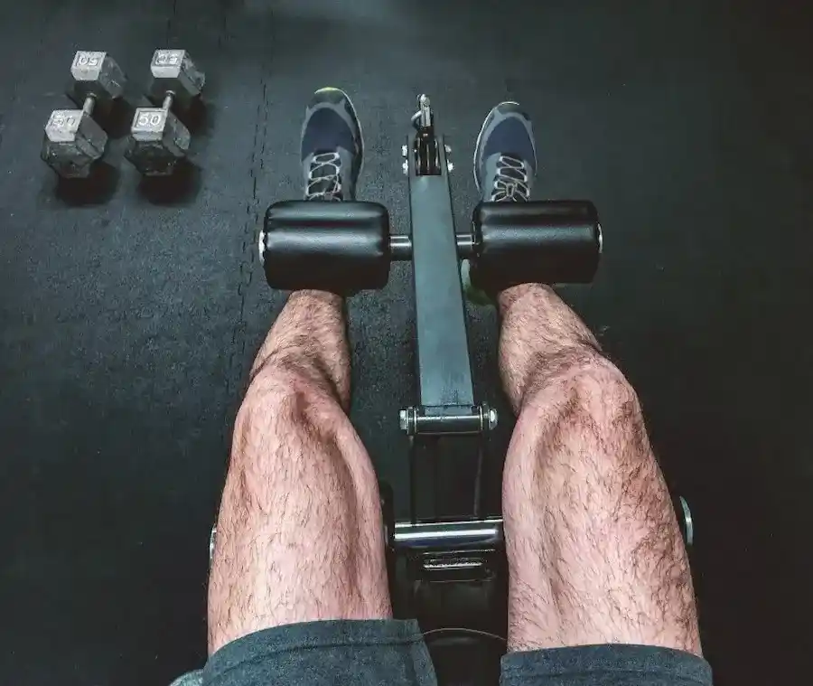 point-of-view-man-using-leg-curl-home-gym-fitness-equipment-with-dumbbells-on-floor-personal_t20_Zz3N3b